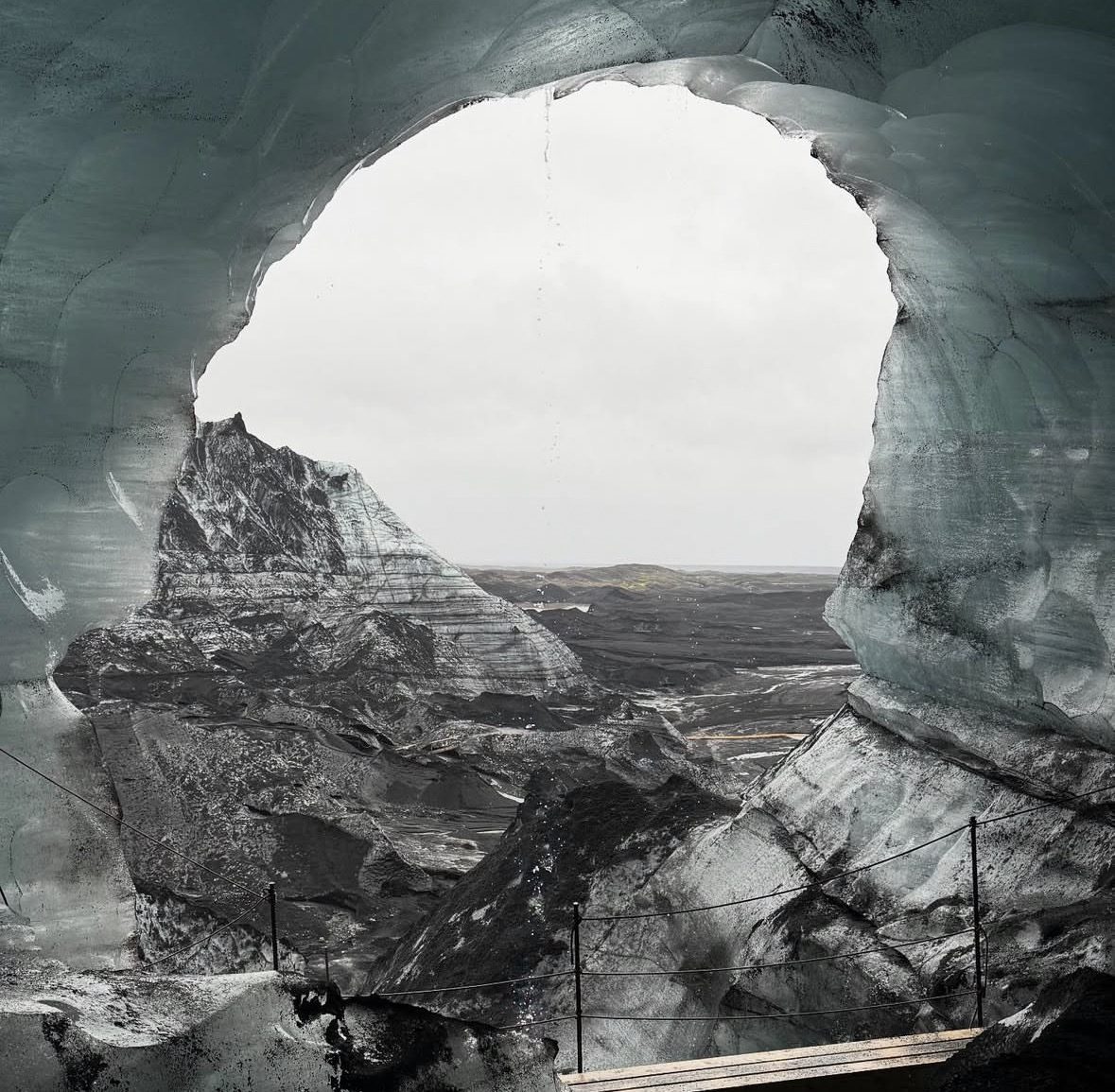Des touristes à l'intérieur de la grotte de glace du Katla explorant des formations de glace bleue et noire sous le glacier Mýrdalsjökull en Islande